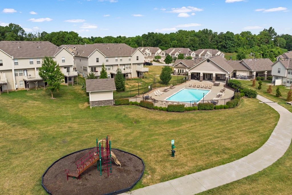 an aerial view of a yard with a pool and houses