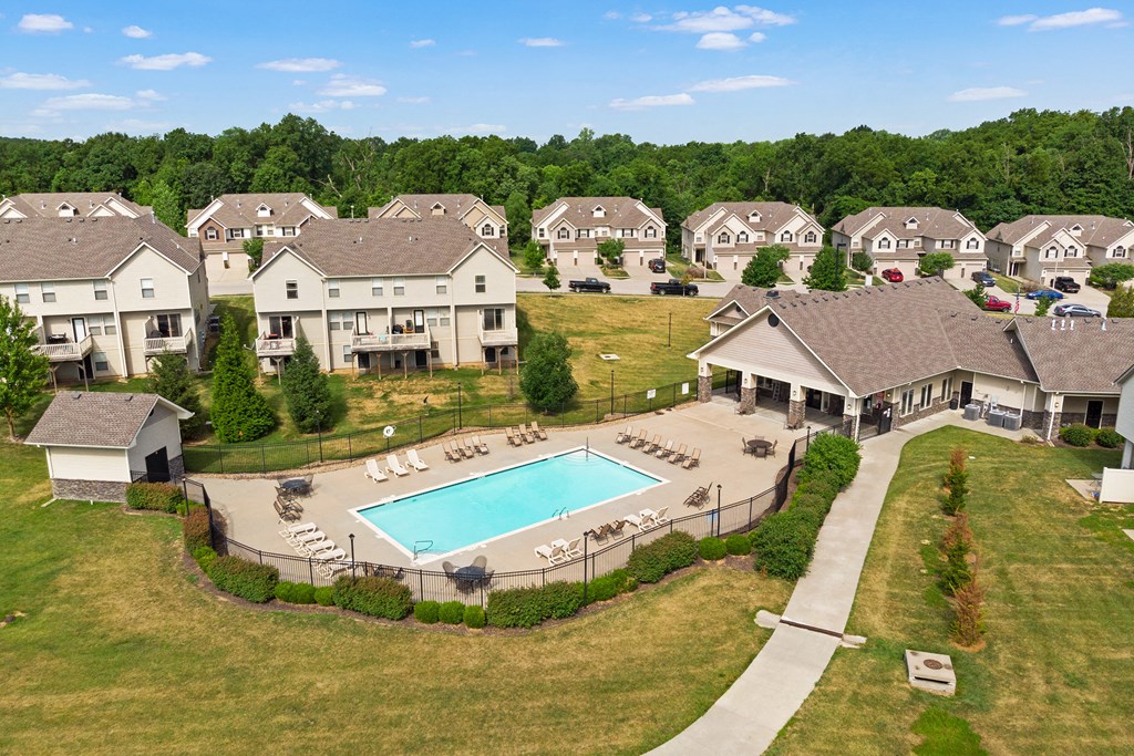 an aerial view of a swimming pool in front of houses