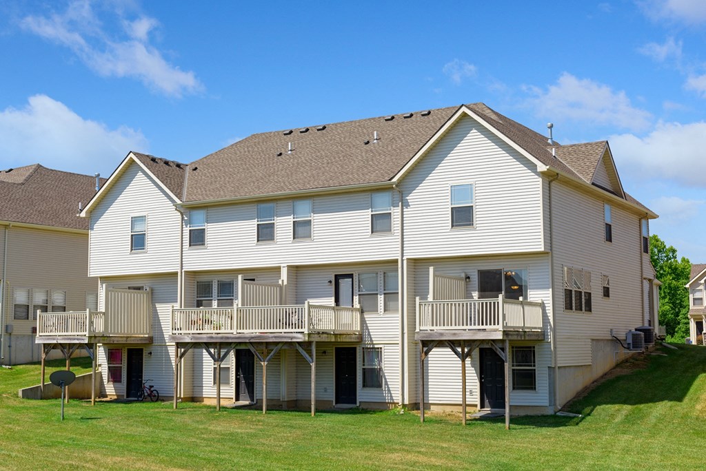 rear view of a large white house with a porch and balconies