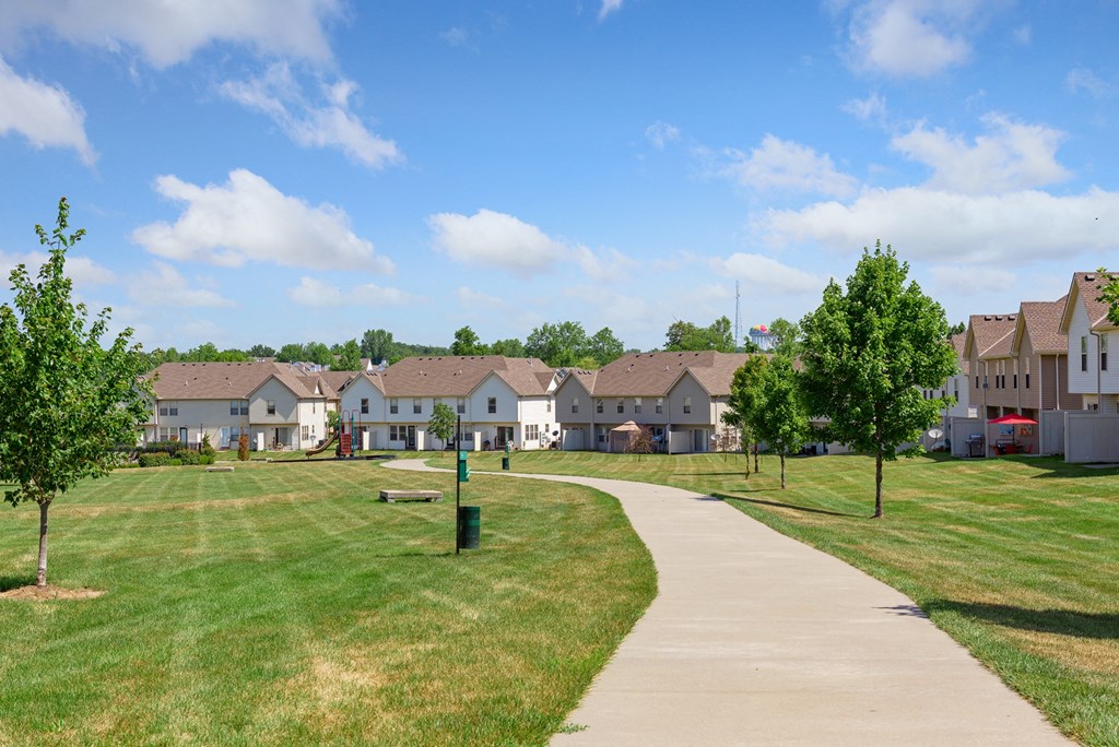 a row of houses in a park with a sidewalk