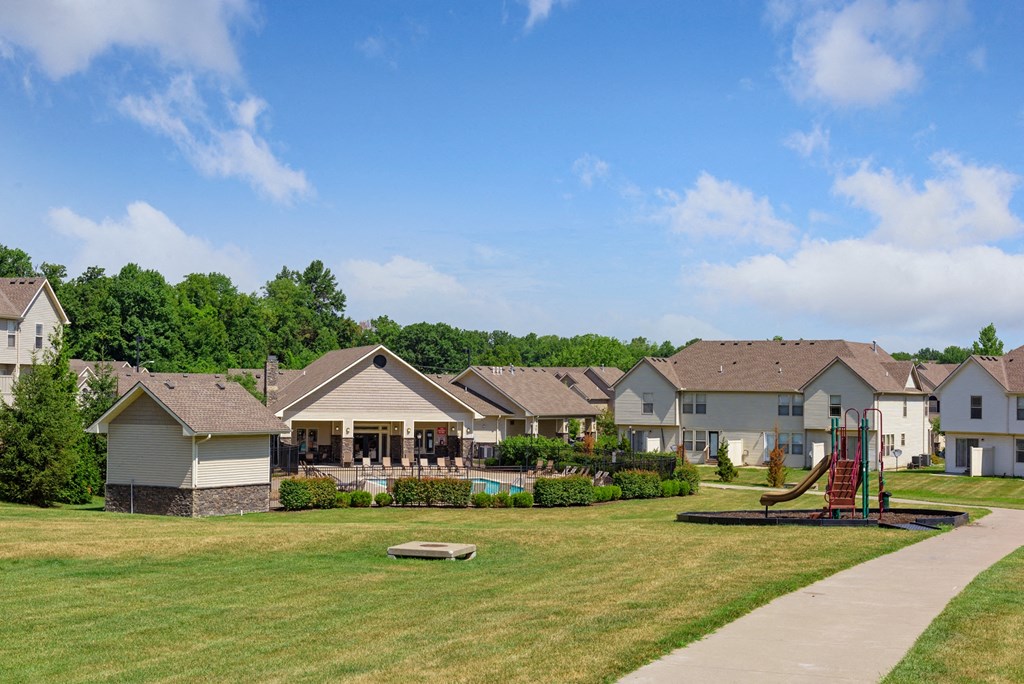 a neighborhood of houses with a yard with a swing set