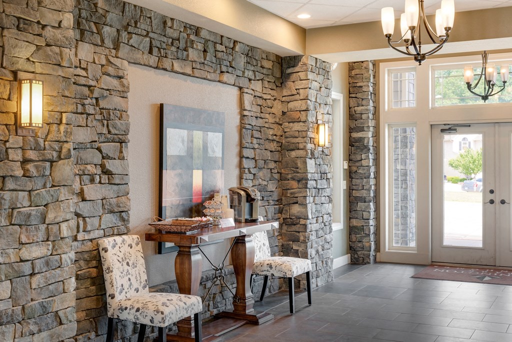 a dining room with stone walls and a table and chairs