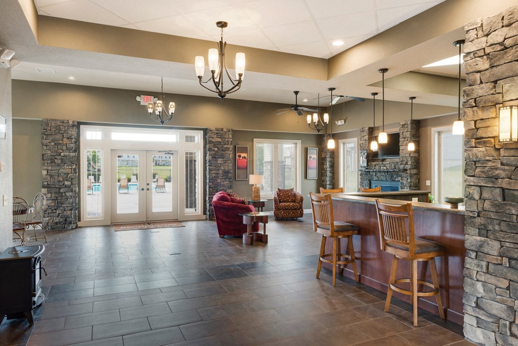 a large living room with a bar and a stone wall