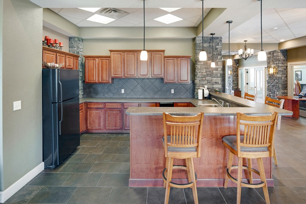 a kitchen with a large island with three chairs
