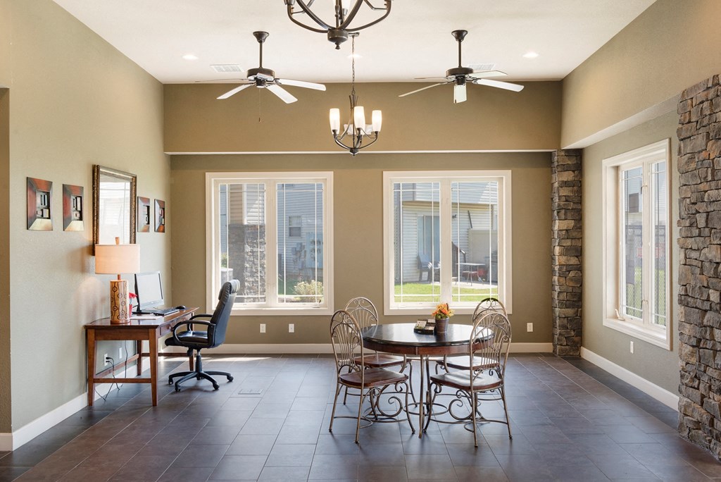 a dining room with a table and chairs and two ceiling fans