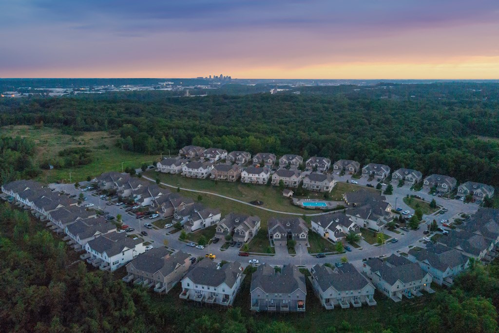 an aerial view of a neighborhood of houses at sunset