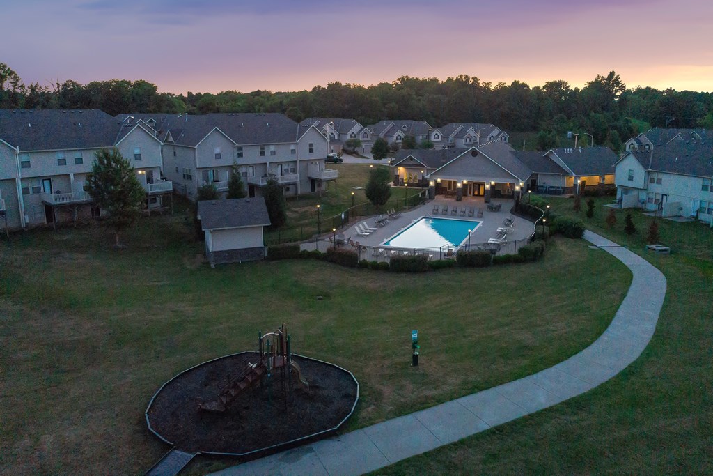 an aerial view of a yard with a pool and houses