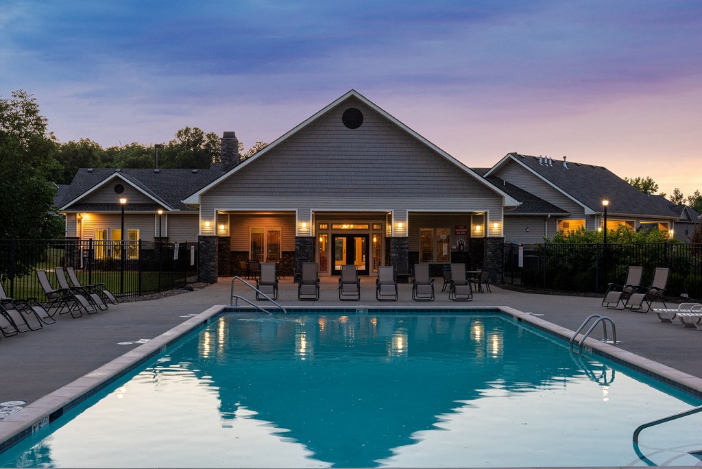 a swimming pool in front of a house at dusk