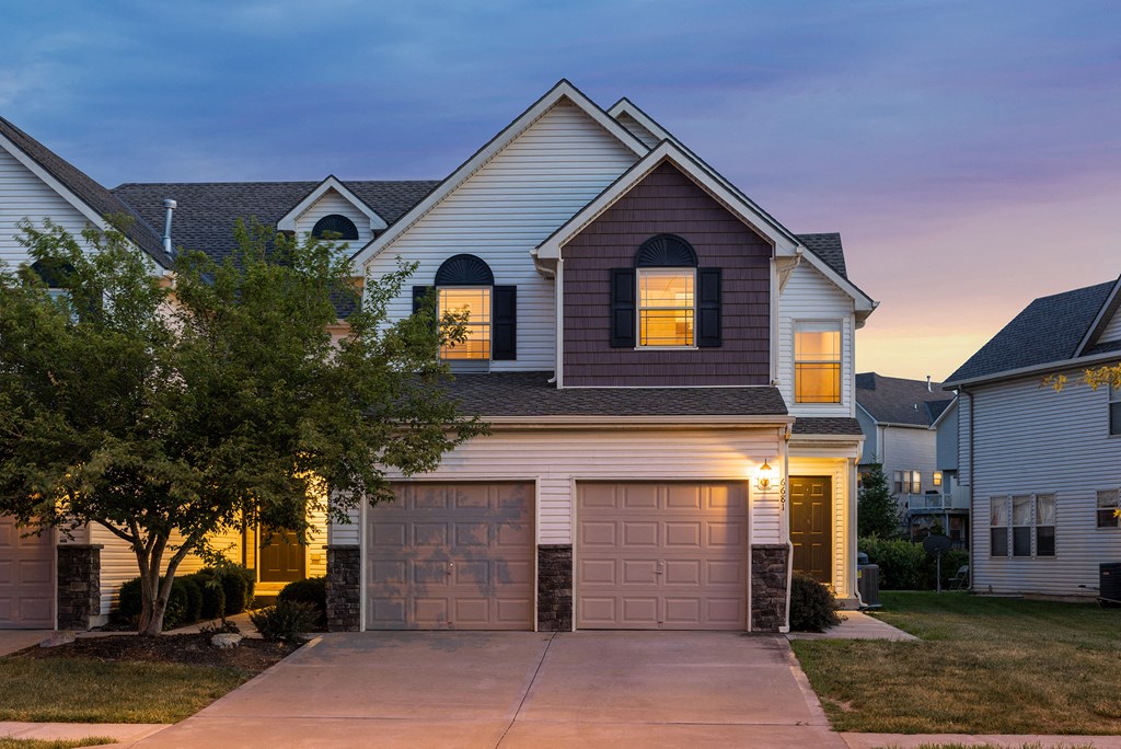 a house with a garage door lit up at dusk