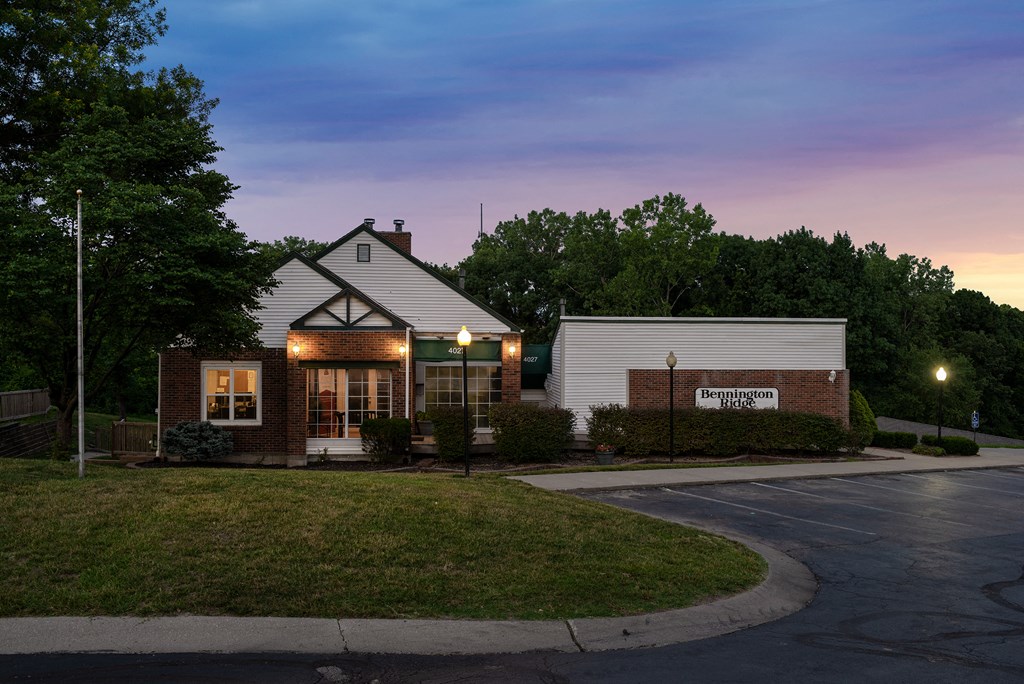 the front of a brick building with a sunset in the sky