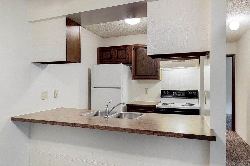 an empty kitchen with a sink and a refrigerator