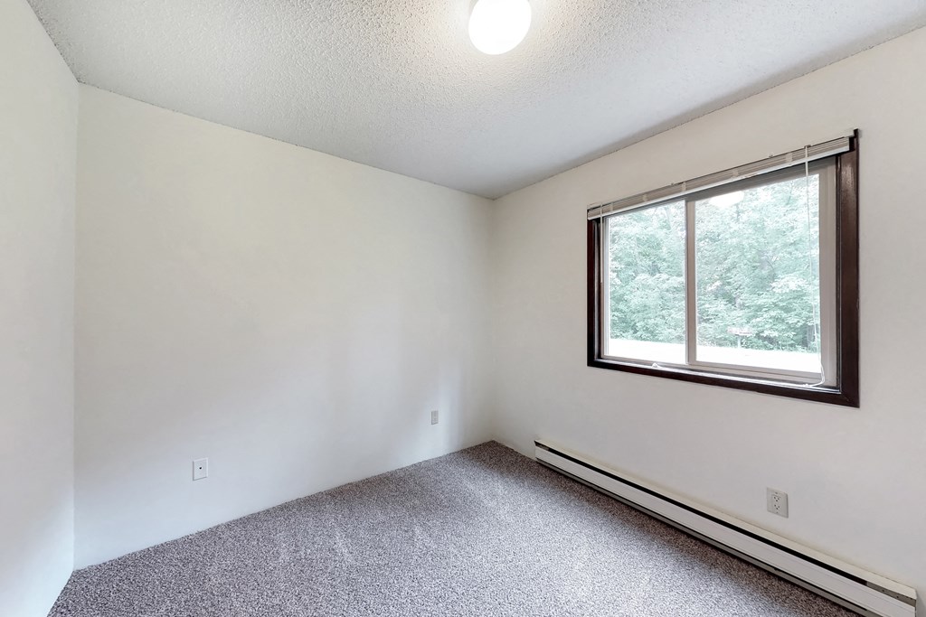 the living room of an empty home with a large window
