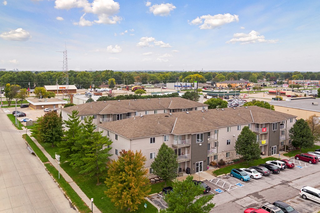 an aerial view of an apartment complex with cars parked in a parking lot