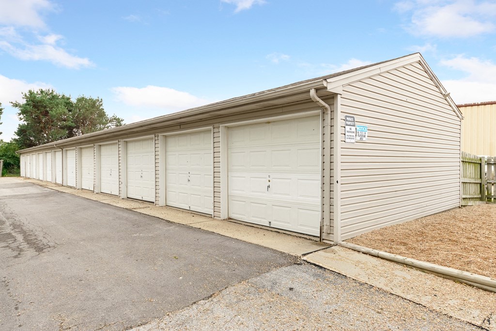 a white garage with white doors on the side of a building