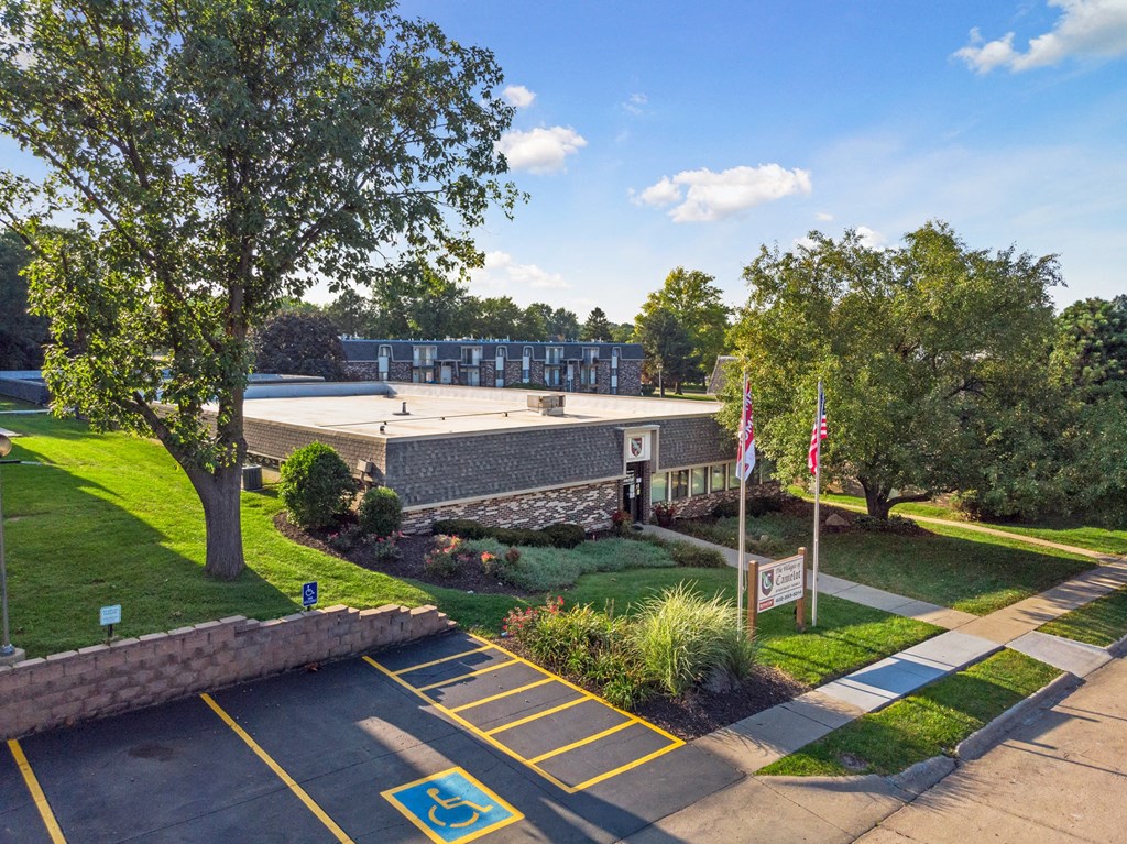 the front of a building with a lawn and trees