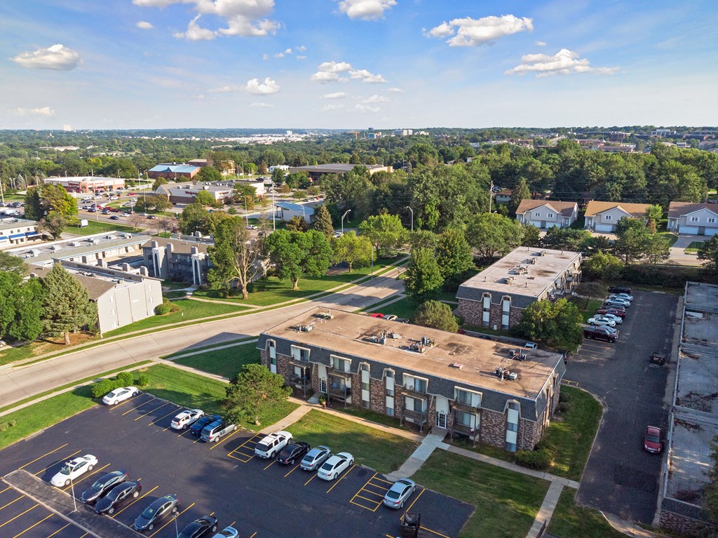 an aerial view of an apartment complex with cars parked in the parking lot