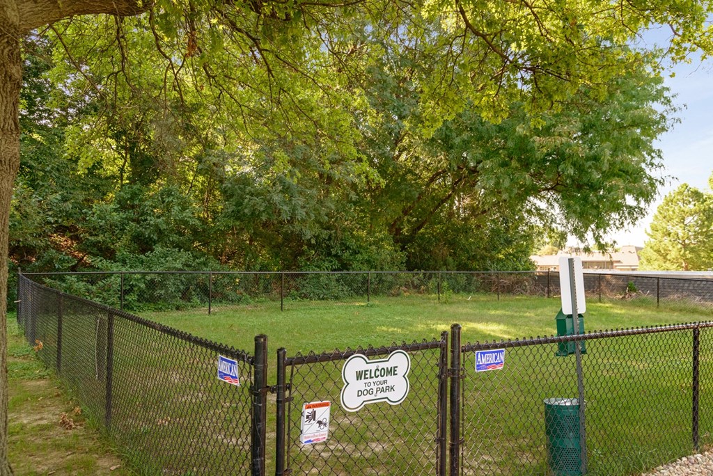 a fence with a sign on it in front of a dog park