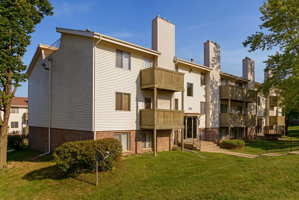 an apartment building with a yard and a balcony