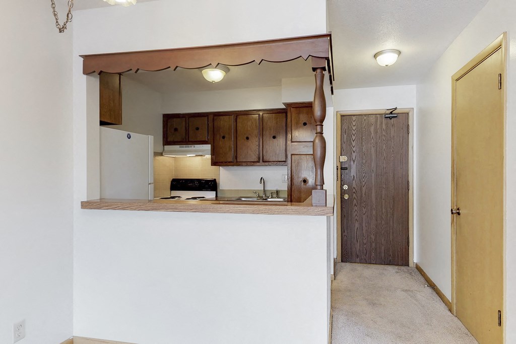 an empty kitchen with a door to the living room