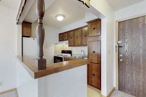 a kitchen with wooden cabinets and a counter top with a stove and sink