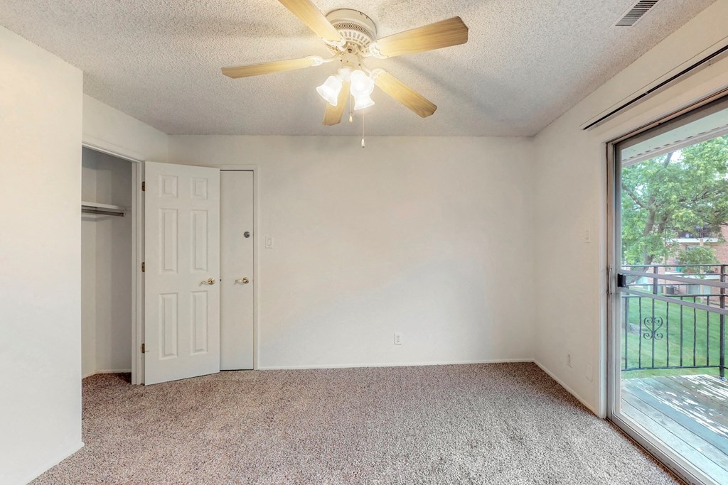 the living room has a large window and a ceiling fan