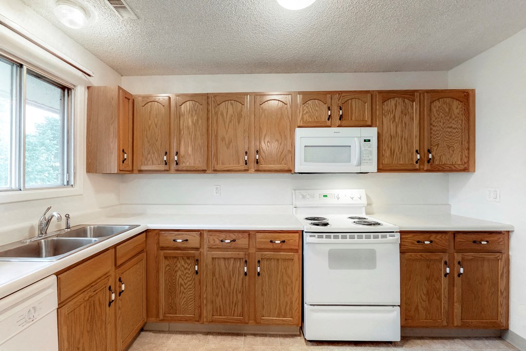 a kitchen with white appliances and wooden cabinets