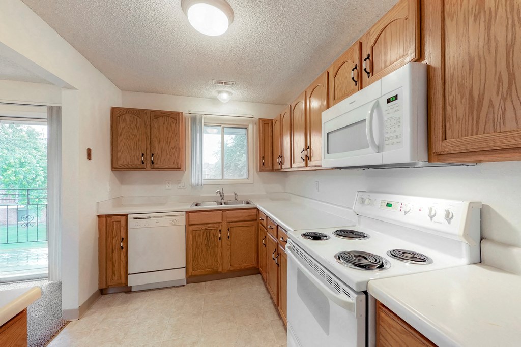 a kitchen with white appliances and wooden cabinets