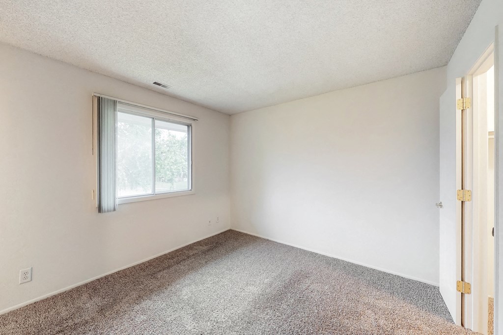 an empty room with carpet and a window