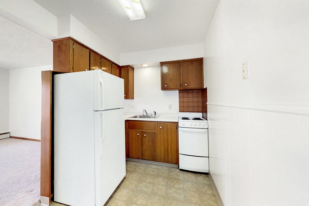 a kitchen with white appliances and wooden cabinets