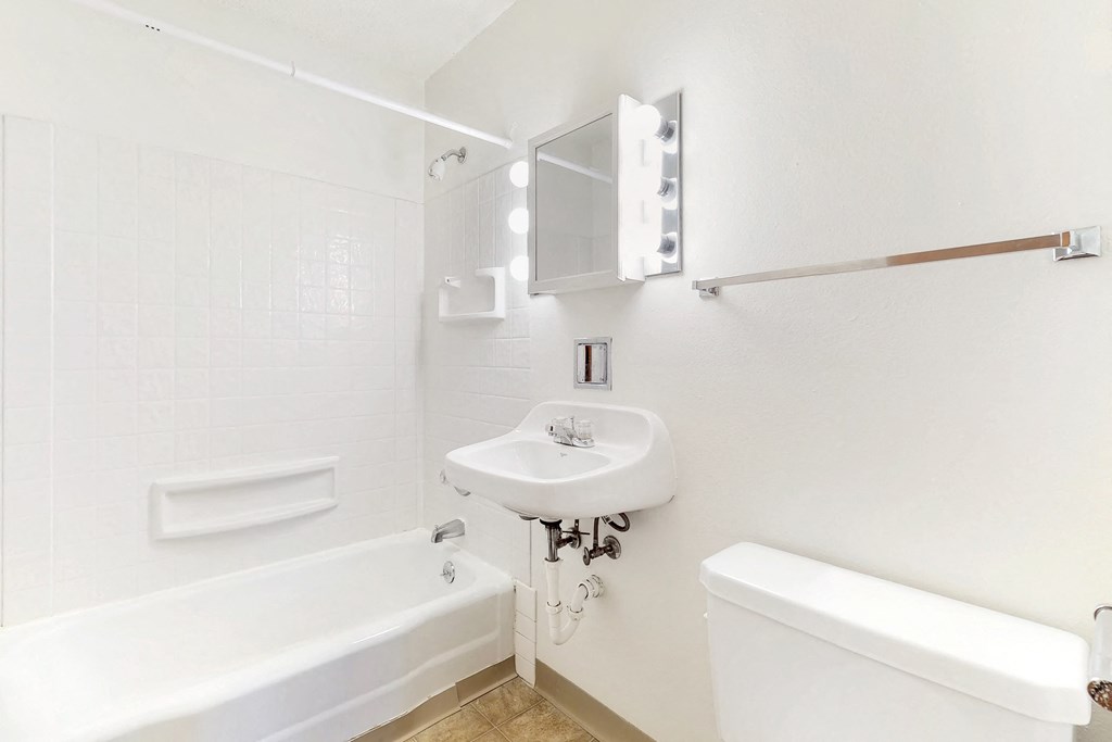 a white bathroom with a sink and a tub