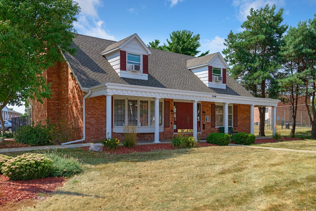 the front of a house with a lawn and a porch