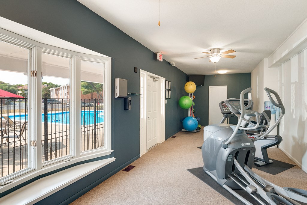 the gym at 1861 muleshoe road with a pool and windows