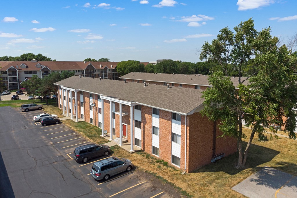 a brick building with cars parked in a parking lot