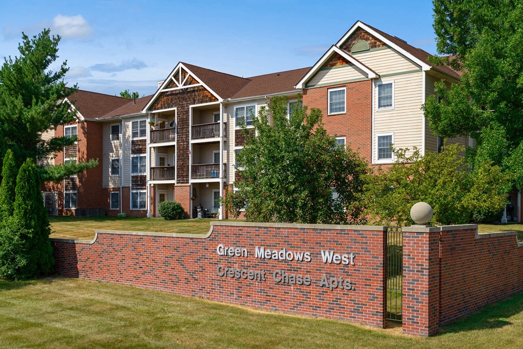 a brick wall with a sign in front of an apartment building