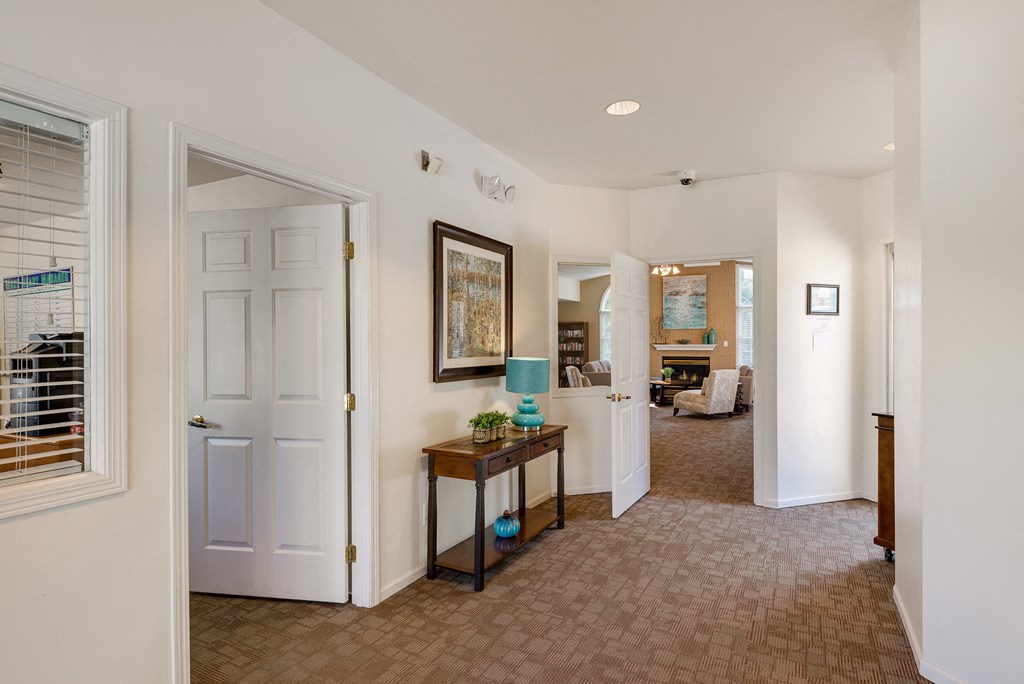 a living room with a door to a hallway and a door into a bedroom