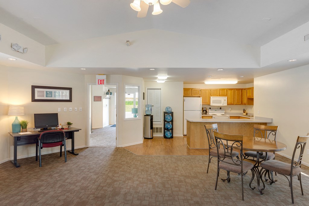 a living room with a kitchen and a dining room table and chairs