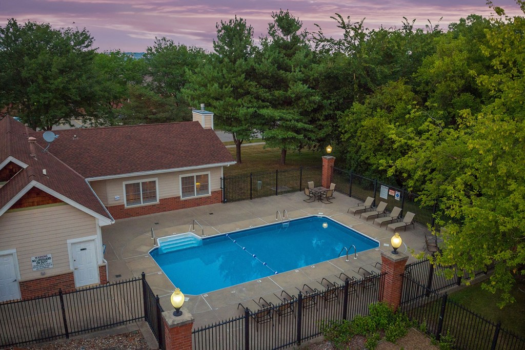 an aerial view of a pool and a house with a swimming pool