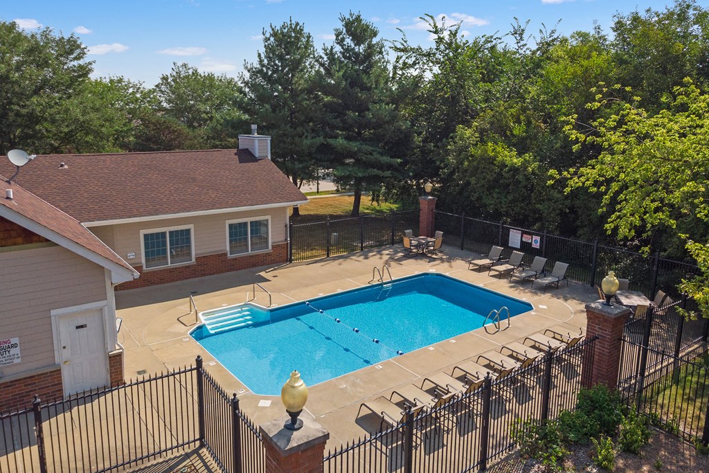 a pool with chairs and a house with a swimming pool