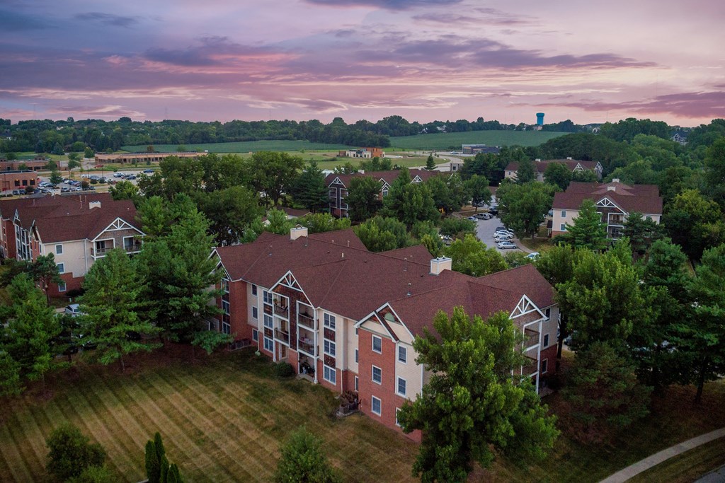 an aerial view of an apartment complex with a sunset in the background