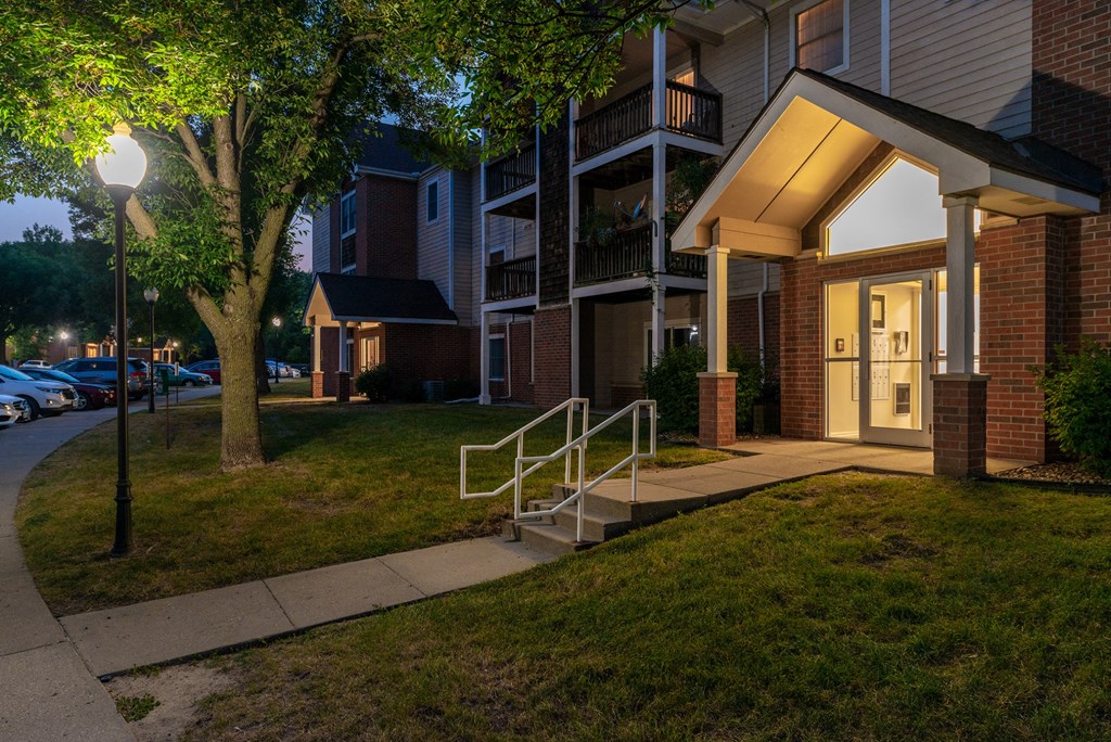 the entrance to a building at night with a lit up porch