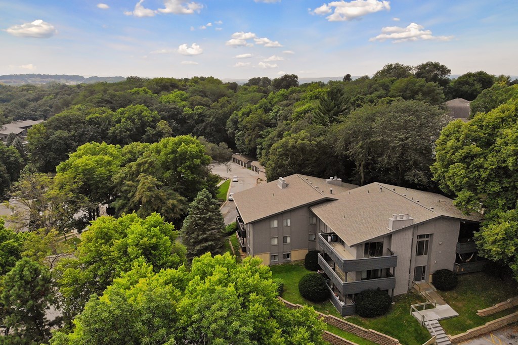 a aerial view of a house surrounded by trees and a building