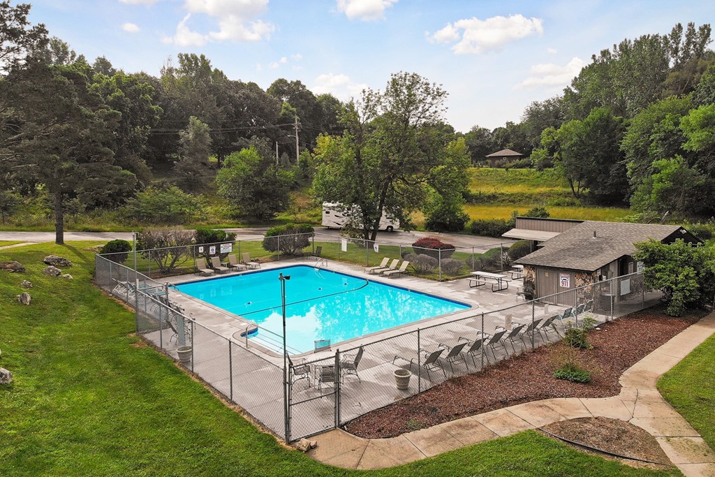 a swimming pool in a backyard with a fence around it
