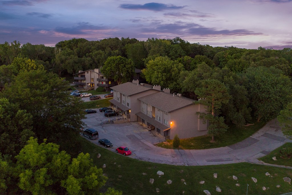 an aerial view of a house with its lights on at dusk