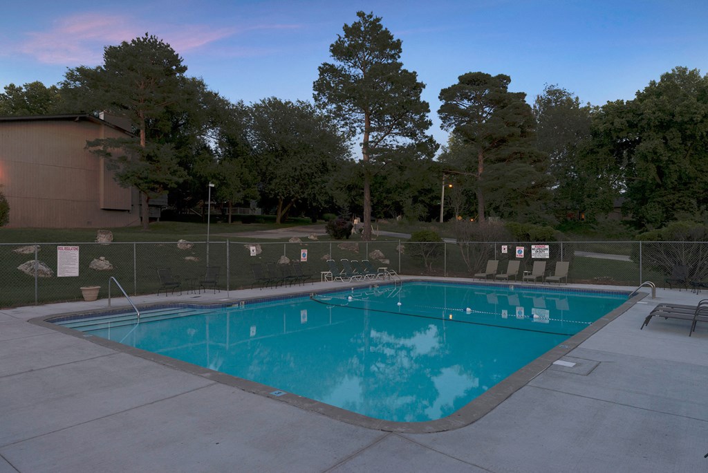 a swimming pool at a hotel with a fence around it