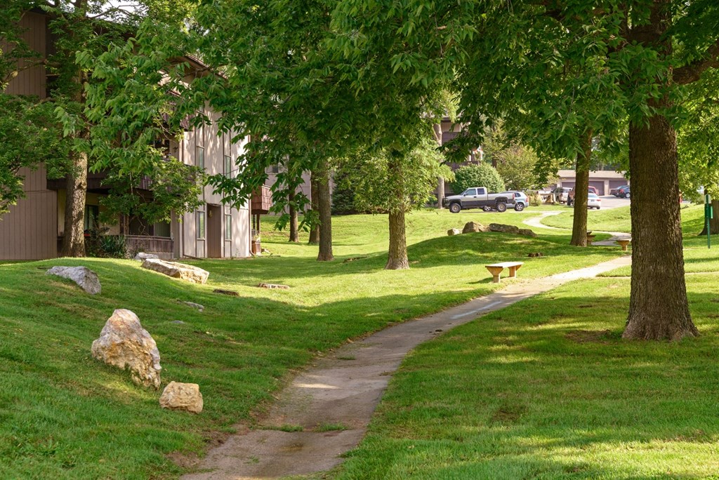 a path through a park with houses and trees