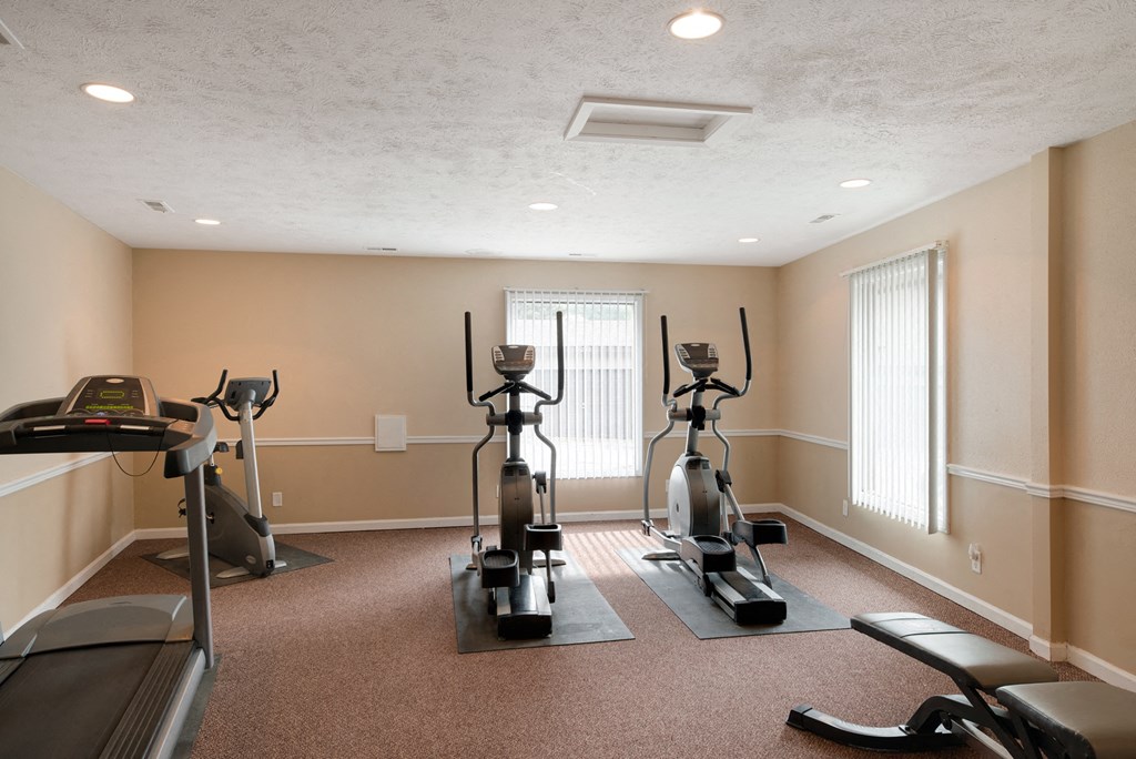 a gym with exercise equipment in the corner of a room