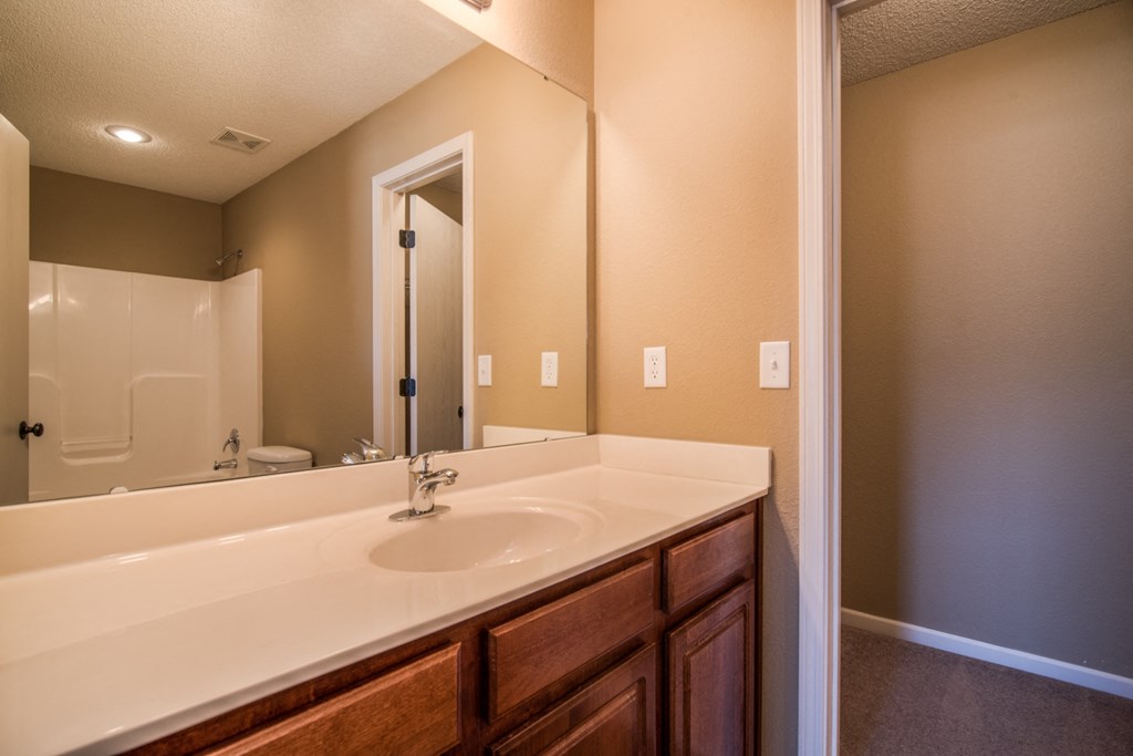 the private bathroom includes a large mirror and a sink