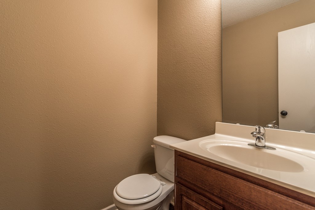 a bathroom with a sink toilet and a mirror