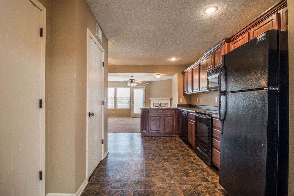 a kitchen with black appliances and wooden cabinets