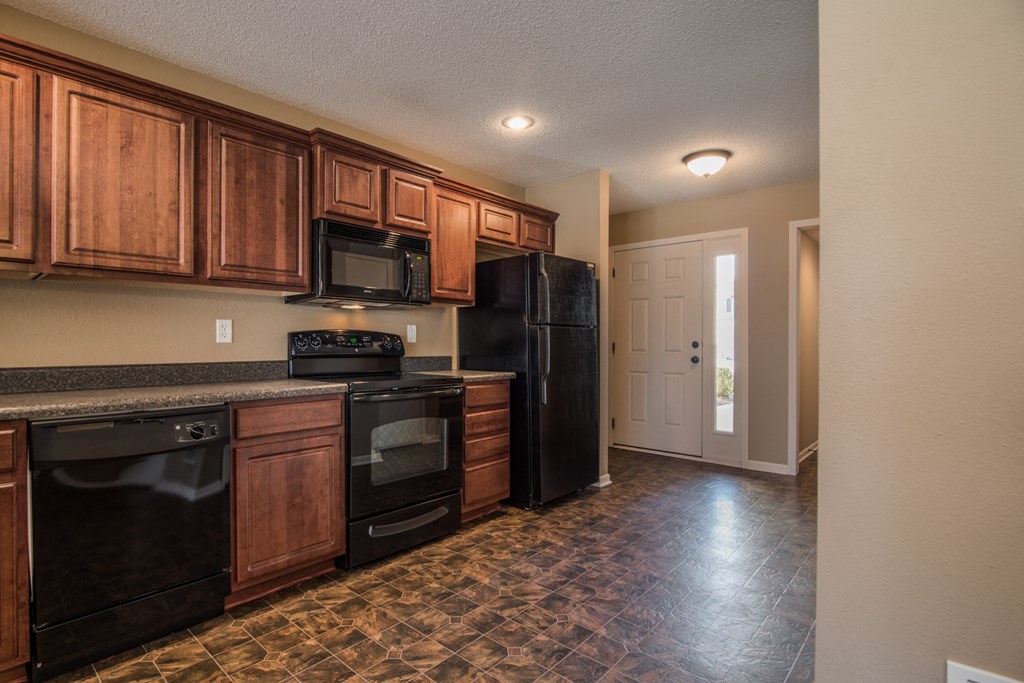 a kitchen with black appliances and wooden cabinets